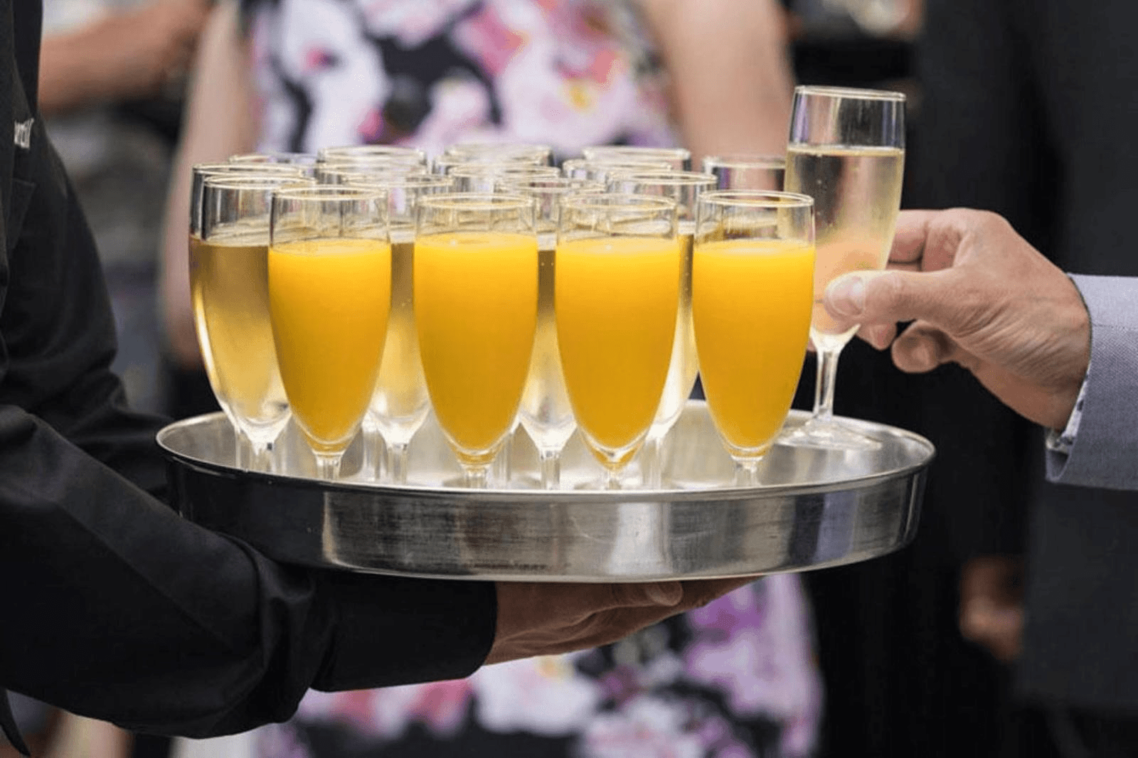 Serveertray met glazen sinaasappelsap en champagne, klaar om uitgedeeld te worden tijdens een babyborrel of feest