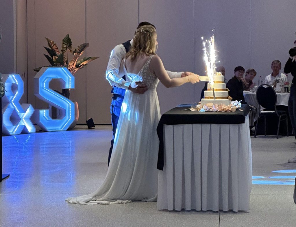 Bruidspaar dat de bruidstaart aansnijdt tijdens het trouwfeest.