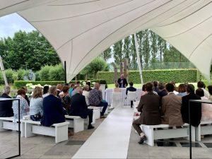Intieme trouwceremonie met gasten zittend onder een moderne overkapping.