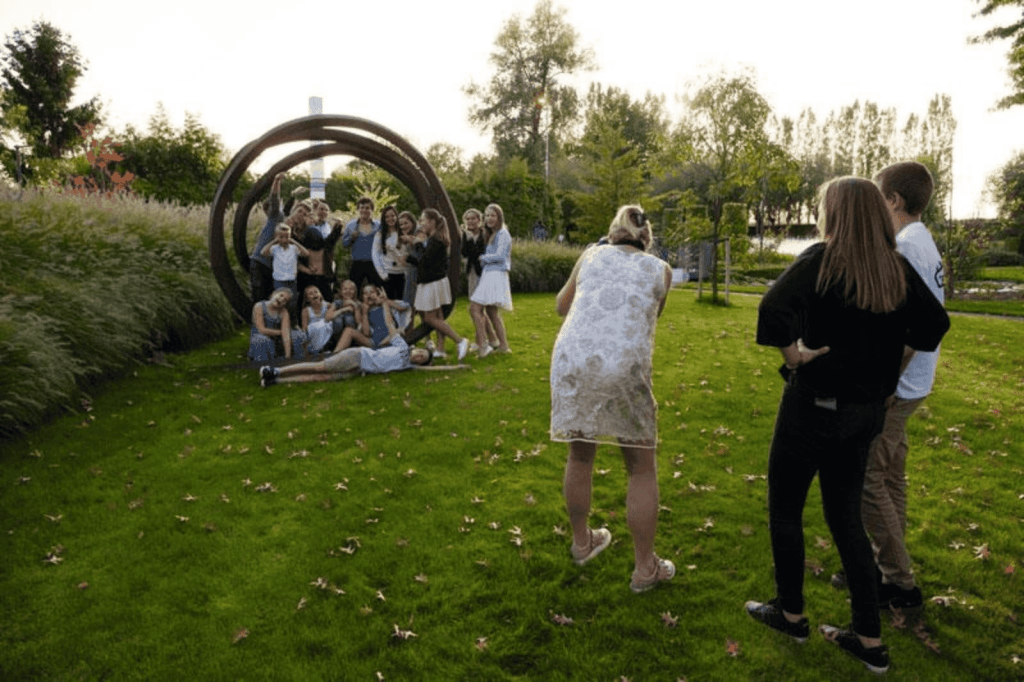 Kinderen en familie vieren een communiefeest in een tuin, met spelende kinderen en een feestelijke sfeer in openlucht